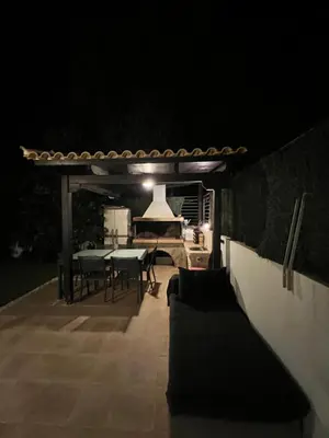 a patio at night with a table and chairs at Апартаменты в Вари in Vari