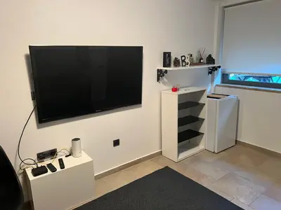 a living room with a flat screen tv on a wall at Апартаменты в Вари in Vari