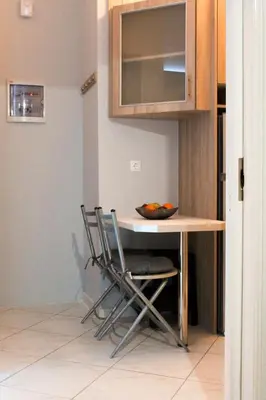 a kitchen table with two chairs and a bowl on it at 50 Steps Apart Metro Neos Kosmos in Athens