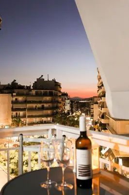 a bottle of wine sitting on a table with wine glasses at 50 Steps Apart Metro Neos Kosmos in Athens