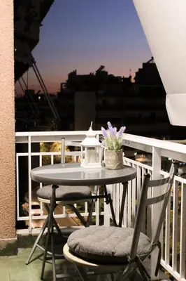 a table and two chairs on a balcony at 50 Steps Apart Metro Neos Kosmos in Athens