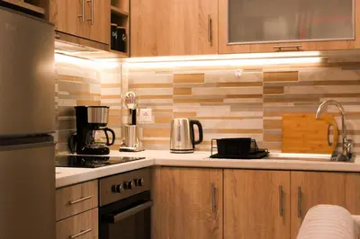 a kitchen with wooden cabinets and a counter top at 50 Steps Apart Metro Neos Kosmos in Athens
