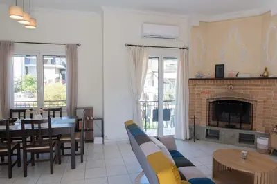 a living room with a table and a fireplace at Cozy Greek Apartment in Athens
