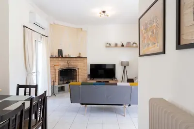 a living room with a tv and a fireplace at Cozy Greek Apartment in Athens