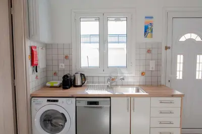 a kitchen with a sink and a washing machine at Cozy Greek Apartment in Athens