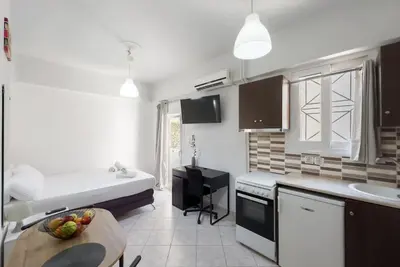 a kitchen with a couch and a table in a room at Pagrati Cozy Retreat in Athens