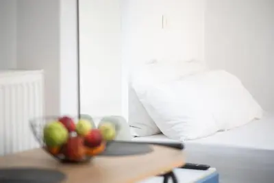 a bowl of fruit on a table next to a bed at Pagrati Cozy Retreat in Athens