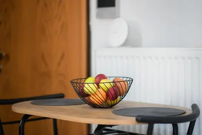 a bowl of fruit sitting on top of a wooden table at Pagrati Cozy Retreat in Athens