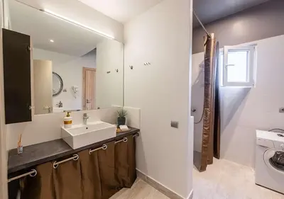 a bathroom with a sink and a washing machine at Spacious 2-Bdrm Apt at Filopappou hill in Koukaki! in Athens