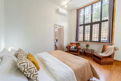 a bedroom with a bed and a large window at Spacious 2-Bdrm Apt at Filopappou hill in Koukaki! in Athens
