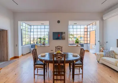 a living room with a table and chairs at Spacious 2-Bdrm Apt at Filopappou hill in Koukaki! in Athens