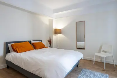 a bedroom with a bed with orange pillows and a mirror at Cosy Athens Downtown Apartment in Athens