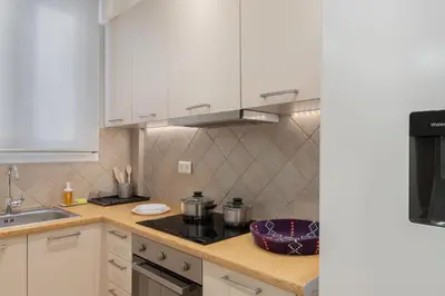 a kitchen with white cabinets and a stove top oven at Cosy Athens Downtown Apartment in Athens