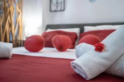 a bed with red and white pillows on it at NEW Boutique Athens HEART Kypseli in Athens
