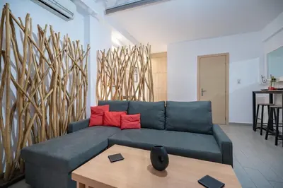 a living room with a blue couch and a wooden table at NEW Boutique Athens HEART Kypseli in Athens