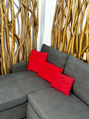 two red pillows sitting on a gray couch with bamboo at NEW Boutique Athens HEART Kypseli in Athens