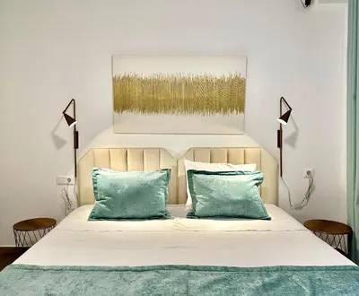 a bedroom with a bed with green pillows at Elaia Luxury Selections - Emerald in Athens