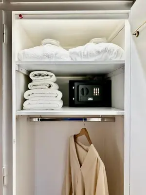 a closet with towels and a clock on a shelf at Elaia Luxury Selections - Emerald in Athens