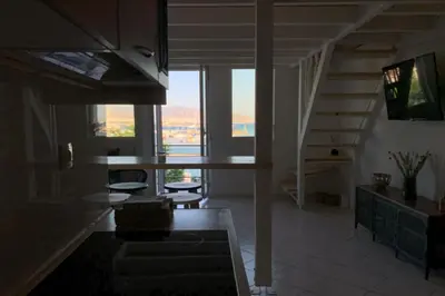 a living room with a staircase with a view of a house at Zefi's Loft - Sea View in Piraeus in Piraeus
