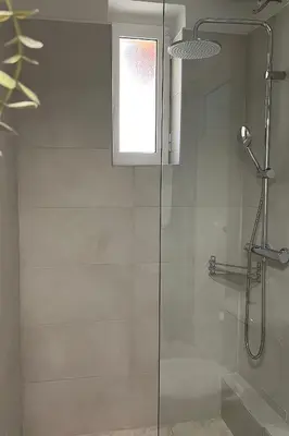a shower with a glass door and a window at Zefi's Loft - Sea View in Piraeus in Piraeus
