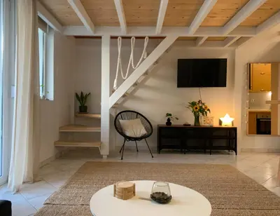 a living room with a table and a tv at Zefi's Loft - Sea View in Piraeus in Piraeus