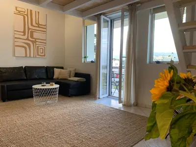 a living room with a couch and a table at Zefi's Loft - Sea View in Piraeus in Piraeus