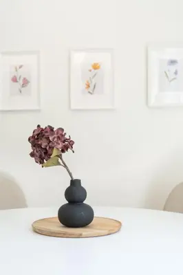 a black vase with a flower in it on a table at Modern apartment at Edem beach in Athens