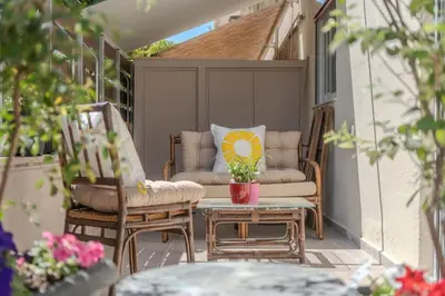 a patio with two chairs and a table and a couch at Modern apartment at Edem beach in Athens