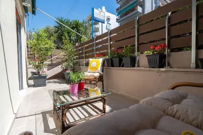 a balcony with a couch and a glass table at Modern apartment at Edem beach in Athens