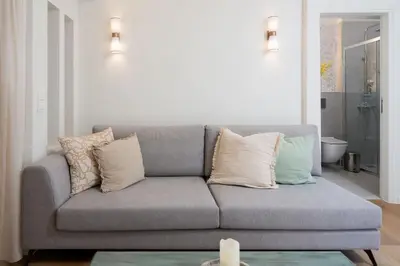 a living room with a gray couch with pillows at Modern apartment at Edem beach in Athens