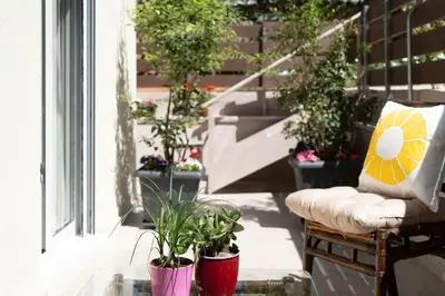 a patio with potted plants and a bench on a porch at Modern apartment at Edem beach in Athens