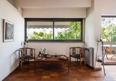 a dining room with a table and two chairs and a window at Lycabettus view Vintage penthouse flat in Exarchia in Athens