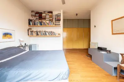 a bedroom with a bed and a desk and books at Lycabettus view Vintage penthouse flat in Exarchia in Athens