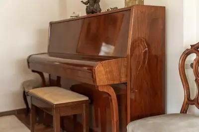 a wooden piano with a chair next to it at Lycabettus view Vintage penthouse flat in Exarchia in Athens