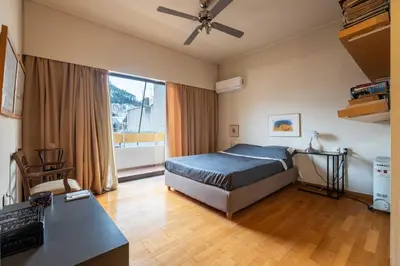 a bedroom with a bed and a desk with a computer at Lycabettus view Vintage penthouse flat in Exarchia in Athens