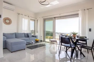 a living room with a couch and a table at Era Suites Lagonisi in Kalívia Thorikoú