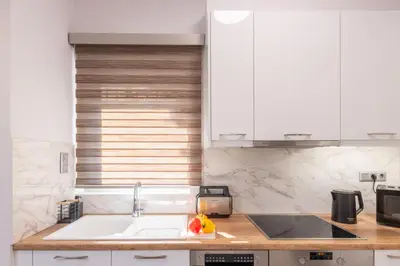 a kitchen with a sink and a counter top at Era Suites Lagonisi in Kalívia Thorikoú