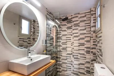 a bathroom with a sink and a mirror at Era Suites Lagonisi in Kalívia Thorikoú
