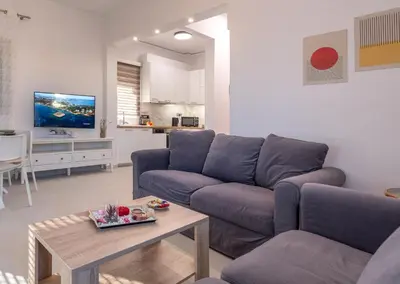 a living room with a couch and a table at Era Suites Lagonisi in Kalívia Thorikoú