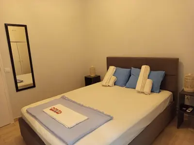 a bedroom with a bed with blue pillows and a mirror at Exarcheia cozy nest in Athens