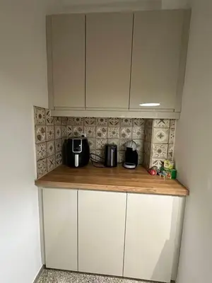 a kitchen with white cabinets and a counter top at Frinis House in Athens
