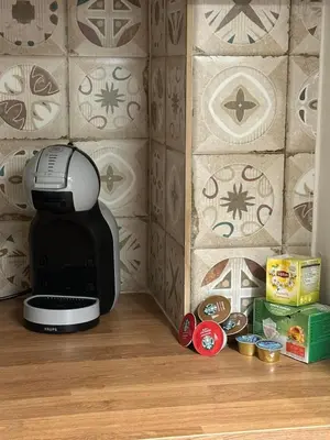 a coffee maker sitting on the floor in front of a wall at Frinis House in Athens