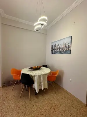 a dining room with a table with orange chairs at Frinis House in Athens