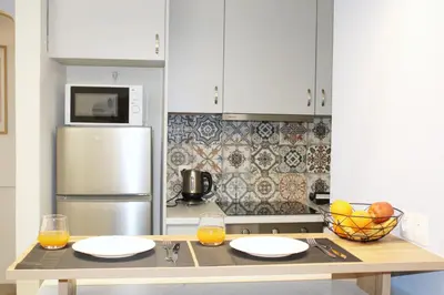a kitchen with a table with two plates and a refrigerator at ARIS central Ampelokipoi in Athens