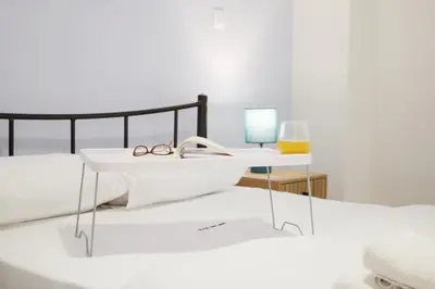 a bed with a white table and glasses on it at ARIS central Ampelokipoi in Athens