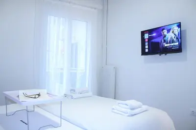 a white room with a bed and a tv on the wall at ARIS central Ampelokipoi in Athens