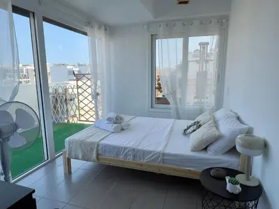 a bedroom with a bed and a large window at Terrace Garden Close To Sea in Athens