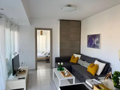 a living room with a blue couch and yellow pillows at Terrace Garden Close To Sea in Athens