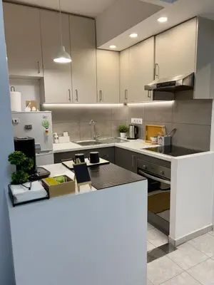 a kitchen with white cabinets and a counter top at Terrace Garden Close To Sea in Athens