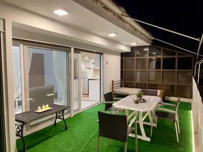 a room with a table and chairs and a balcony at Terrace Garden Close To Sea in Athens